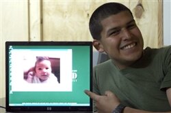 Marine Lance Cpl. Jovan Rodriguez, deployed to Iraq, smiles for the camera shortly after witnessing the birth of his daughter, Liliana, via satellite to New Jersey. He is a warehouse clerk assigned to Task Force 2nd Battalion, 2nd Marines, Regimental Combat Team 5. Rodriguez joined his wife through teleconference at Al Asad Air Base for the birth of their first child, Sept. 10, 2008. Marine photo by Lance Cpl. Joshua Murray. 