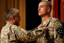 General George W. Casey Jr. presents an Army Commendation Medal to Pfc. Seth Manderscheid during a ceremony Tuesday at Carey Theater.